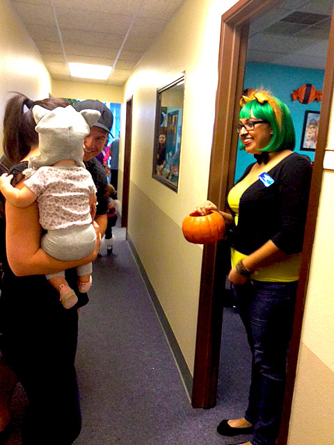 A cat is in the hallway handing out candy.